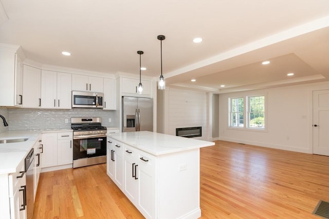 776 Allen St, Dartmouth, MA 02747 - kitchen featuring appliances with stainless steel finishes, light wood-type flooring, backsplash, recessed lighting, and a kitchen island