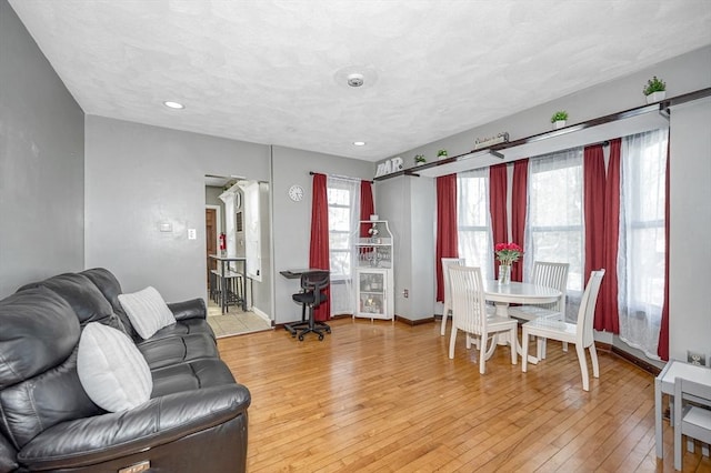 living area with light wood finished floors, baseboards, and recessed lighting