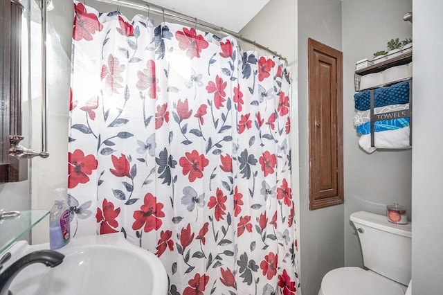 full bath with a sink, curtained shower, and toilet