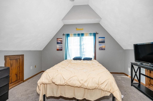 carpeted bedroom featuring lofted ceiling and baseboards