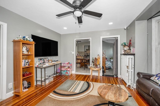 living room with wood finished floors, baseboards, ceiling fan, and recessed lighting