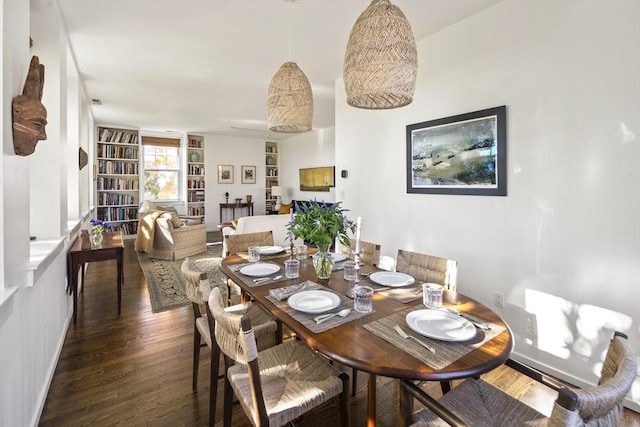 dining space with dark wood-type flooring and built in shelves