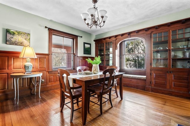 dining area with wood-type flooring and a notable chandelier