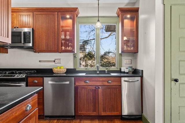 kitchen featuring stainless steel appliances, dark hardwood / wood-style flooring, sink, and hanging light fixtures