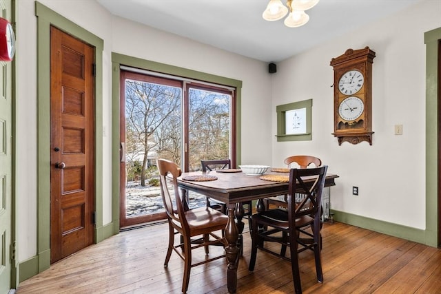 dining space featuring light hardwood / wood-style floors and a chandelier