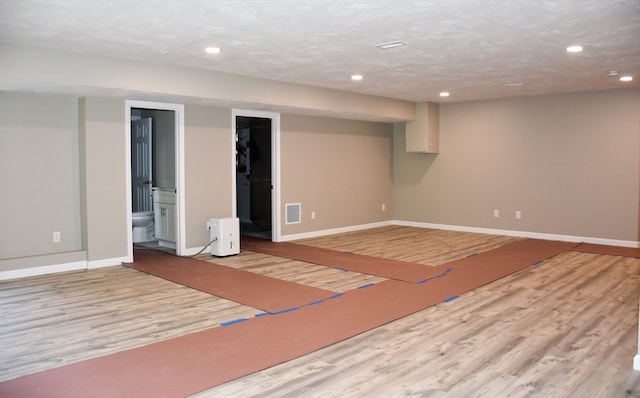 basement with light hardwood / wood-style floors