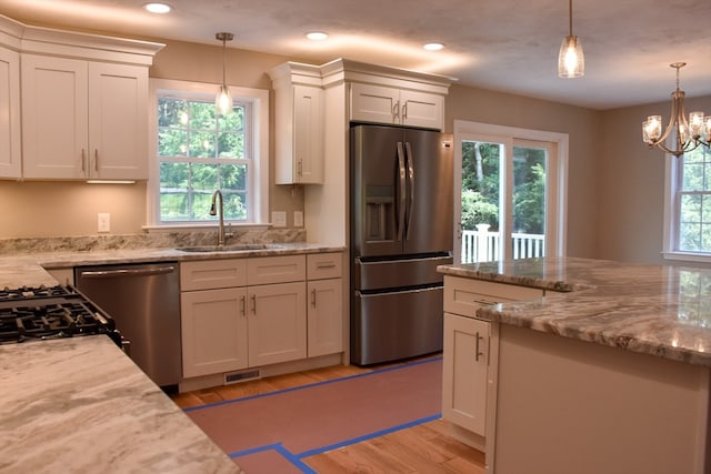 kitchen with light hardwood / wood-style floors, appliances with stainless steel finishes, and plenty of natural light