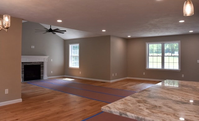 unfurnished living room with vaulted ceiling, light hardwood / wood-style flooring, and ceiling fan