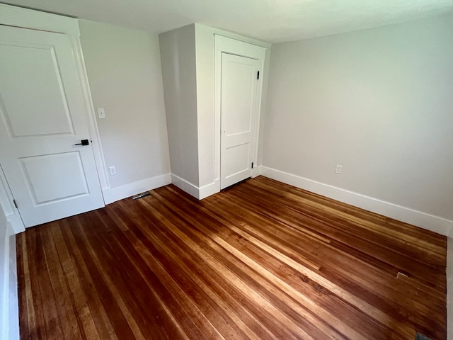 unfurnished bedroom with a closet and wood-type flooring