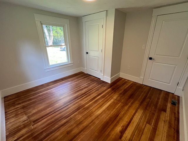 unfurnished bedroom with dark hardwood / wood-style flooring