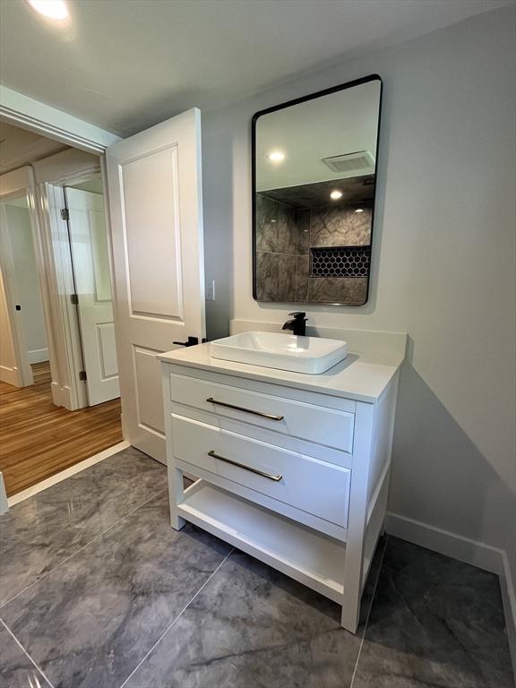 bathroom with visible vents, vanity, and baseboards