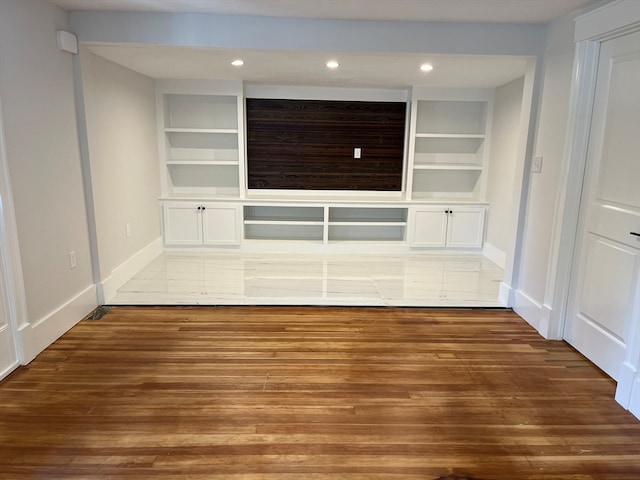 interior space with built in features, hardwood / wood-style floors, and white cabinets