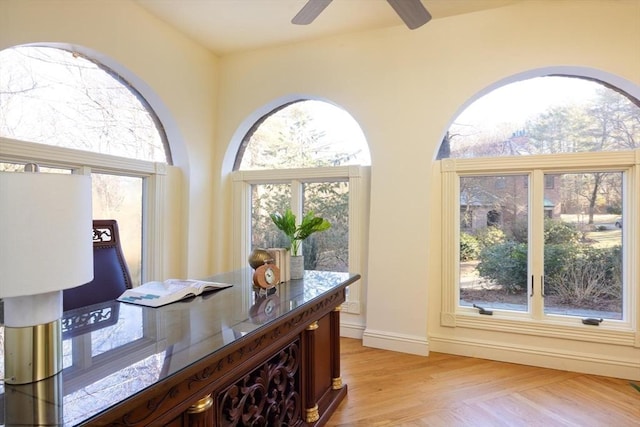 office area featuring ceiling fan, light wood-style flooring, and baseboards