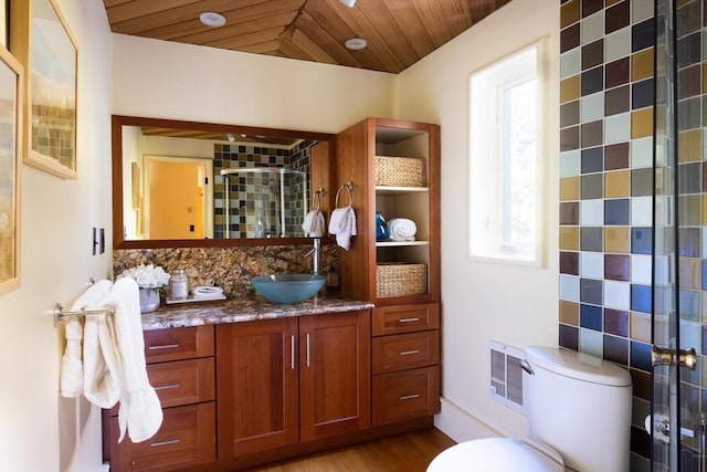 bathroom featuring toilet, wood finished floors, wood ceiling, vanity, and a stall shower