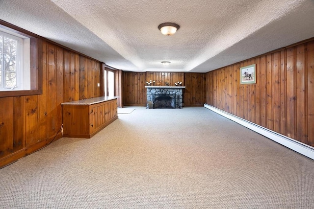 below grade area featuring wooden walls, light colored carpet, and a stone fireplace