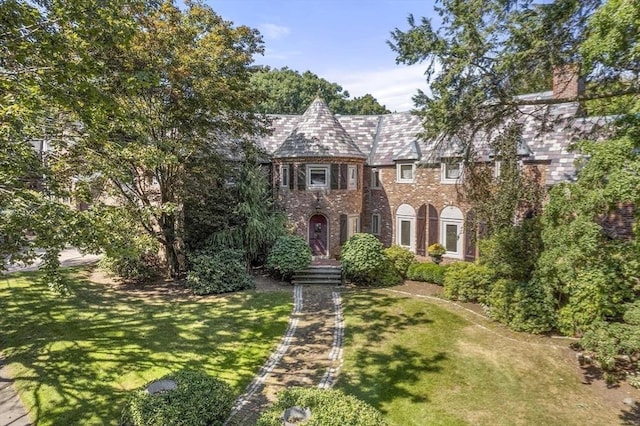 view of front facade featuring brick siding and a front yard