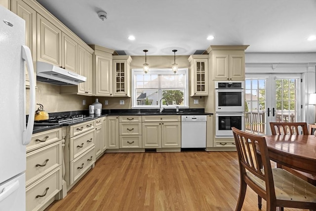 61 Colonial Dr, Arlington, MA 02474 - kitchen with white appliances, under cabinet range hood, cream cabinetry, dark countertops, and recessed lighting