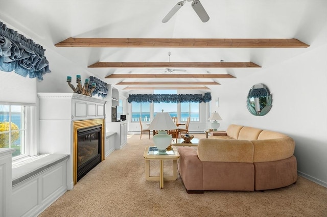 living room featuring plenty of natural light, a glass covered fireplace, light colored carpet, and ceiling fan