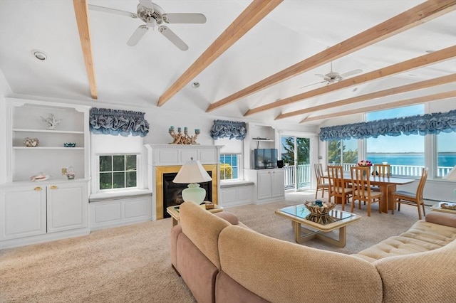 living area with a ceiling fan, a fireplace, and light carpet