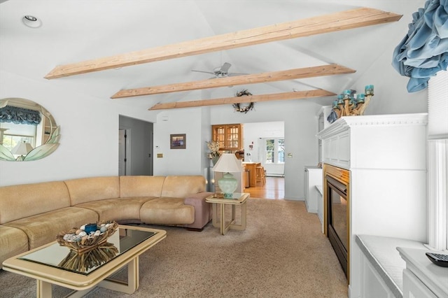 living area featuring a glass covered fireplace, vaulted ceiling with beams, light carpet, and a ceiling fan