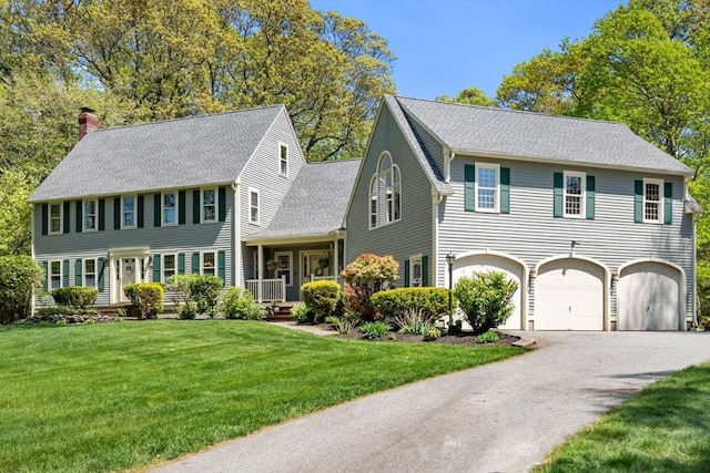 13 Lisa Ln, Georgetown, MA 01833 - colonial-style house with a chimney, driveway, a garage, a front yard, and roof with shingles