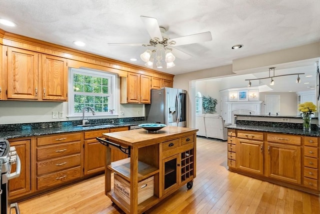 13 Lisa Ln, Georgetown, MA 01833 - kitchen with a sink, appliances with stainless steel finishes, a ceiling fan, brown cabinetry, and light wood finished floors