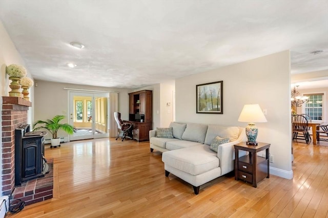 13 Lisa Ln, Georgetown, MA 01833 - living room featuring a chandelier, plenty of natural light, light wood finished floors, and a wood stove