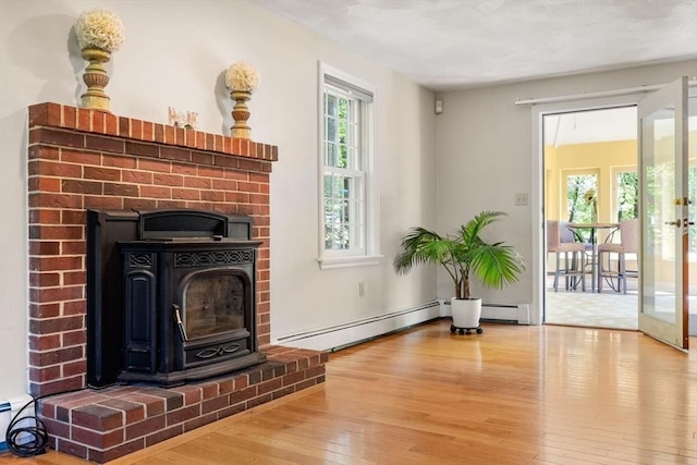 13 Lisa Ln, Georgetown, MA 01833 - unfurnished living room featuring hardwood / wood-style floors, a baseboard radiator, a wood stove, and french doors