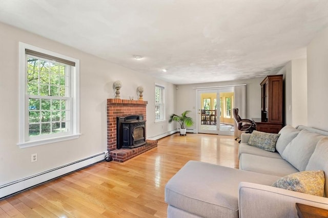 13 Lisa Ln, Georgetown, MA 01833 - living area with a baseboard heating unit, a wood stove, healthy amount of natural light, and light wood-type flooring