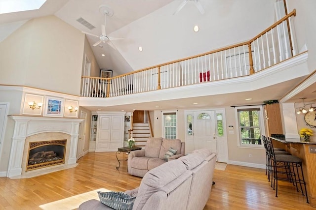 13 Lisa Ln, Georgetown, MA 01833 - living room featuring ceiling fan, light wood-type flooring, stairway, high vaulted ceiling, and a fireplace with flush hearth