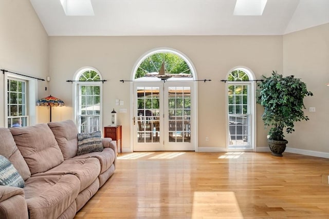 13 Lisa Ln, Georgetown, MA 01833 - living area with a skylight, light wood-style floors, high vaulted ceiling, and baseboards