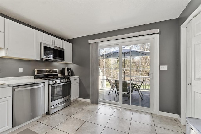 51 Fox Meadow Rd Unit A, Leominster, MA 01453 - kitchen with appliances with stainless steel finishes, white cabinetry, baseboards, and light tile patterned floors