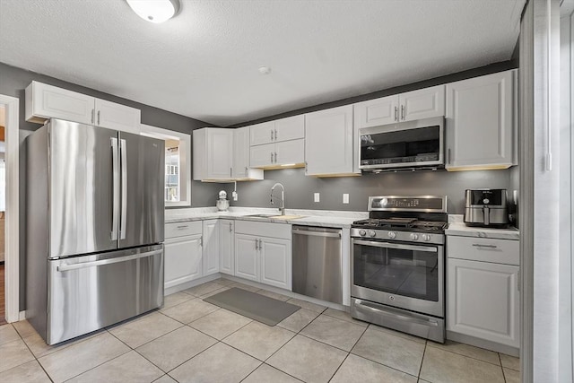 51 Fox Meadow Rd Unit A, Leominster, MA 01453 - kitchen with appliances with stainless steel finishes, a sink, white cabinets, light tile patterned flooring, and a textured ceiling