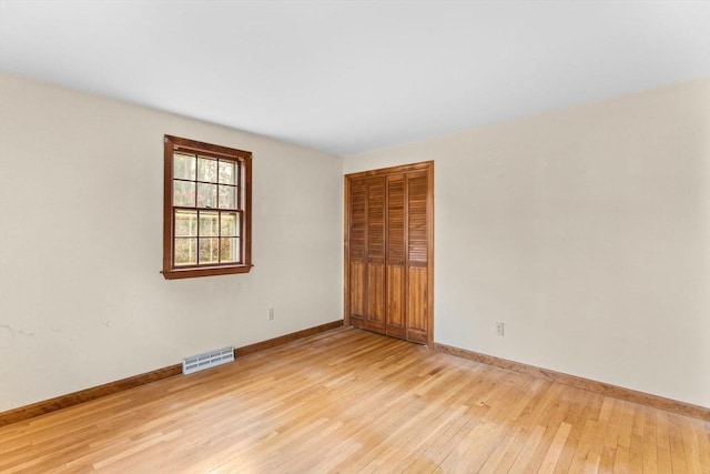 spare room with visible vents, light wood-style flooring, and baseboards