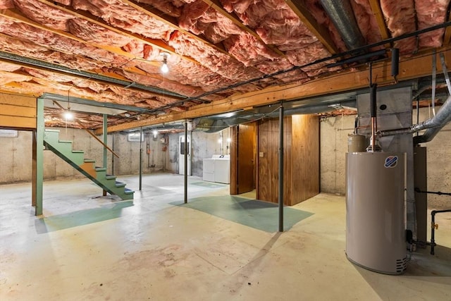 unfinished below grade area featuring stairway, separate washer and dryer, and gas water heater