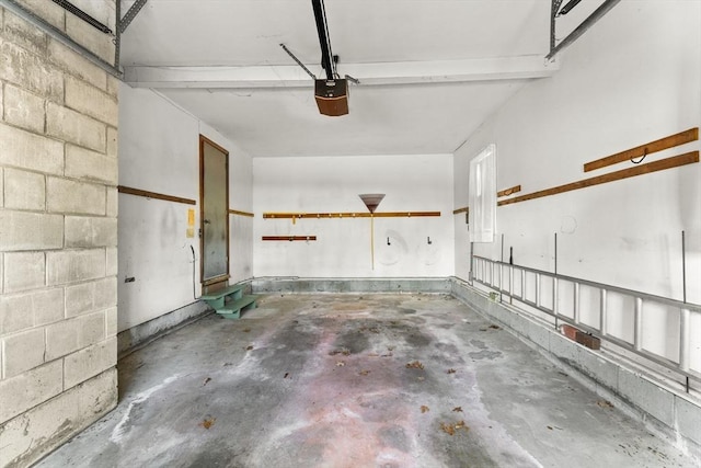 garage with concrete block wall and a garage door opener