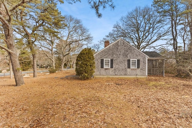 view of side of property with a chimney and a sunroom