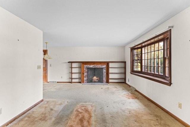 unfurnished living room featuring a brick fireplace, visible vents, and baseboards