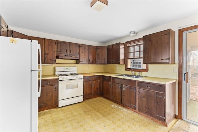 kitchen with white appliances, light countertops, and a sink