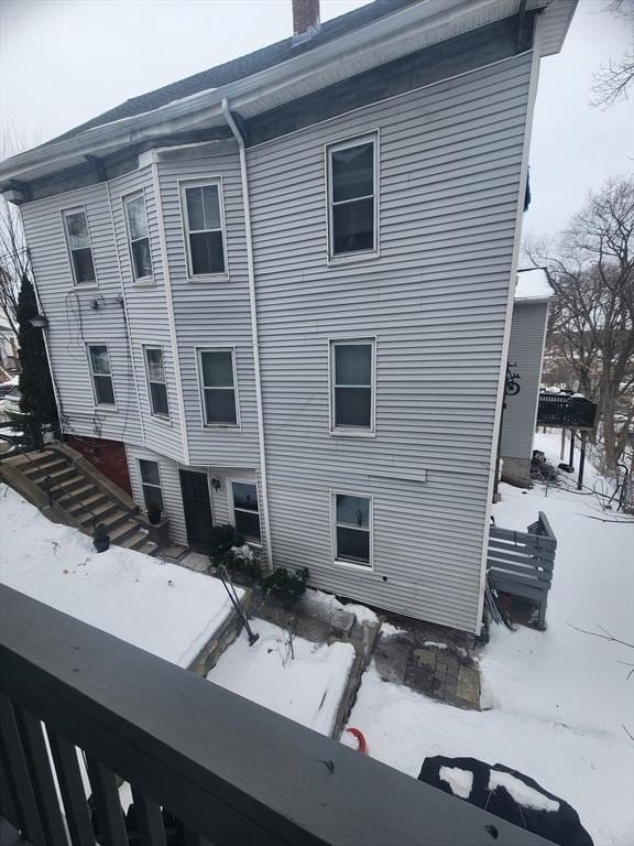 snow covered property featuring a chimney