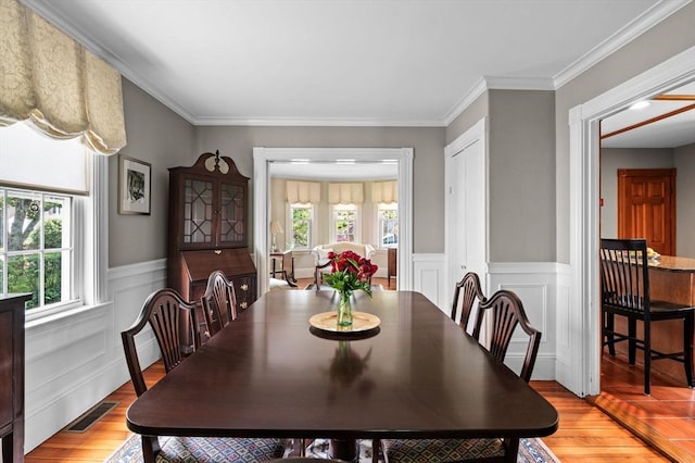 18 E St, Beverly, MA 01915 - dining space featuring light wood-style floors, wainscoting, and crown molding