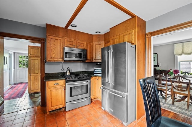 18 E St, Beverly, MA 01915 - kitchen with appliances with stainless steel finishes, brown cabinetry, and dark stone counters