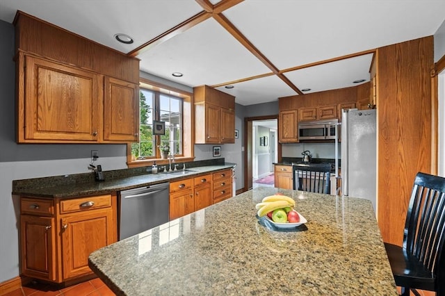 18 E St, Beverly, MA 01915 - kitchen featuring stainless steel appliances, a sink, brown cabinets, stone countertops, and recessed lighting