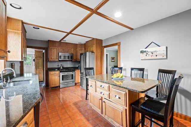 18 E St, Beverly, MA 01915 - kitchen featuring appliances with stainless steel finishes, a sink, a kitchen breakfast bar, dark stone countertops, and recessed lighting