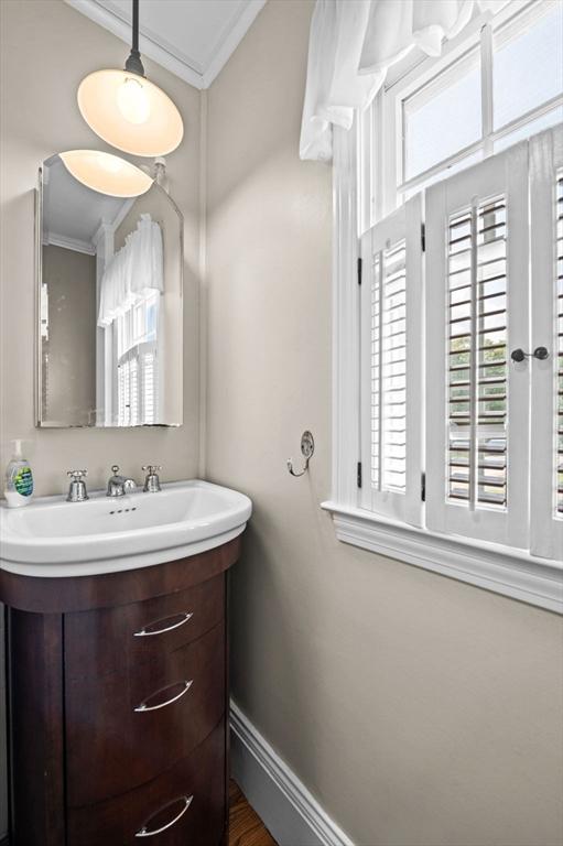 18 E St, Beverly, MA 01915 - bathroom with crown molding, healthy amount of natural light, baseboards, and vanity