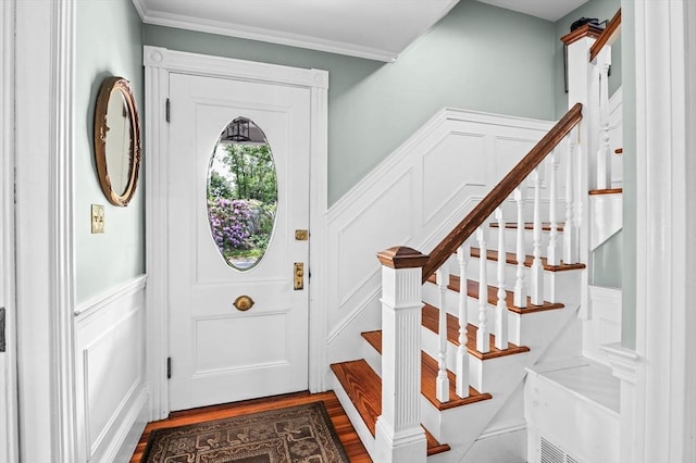 18 E St, Beverly, MA 01915 - entryway featuring a decorative wall, dark wood-type flooring, a wainscoted wall, ornamental molding, and stairway