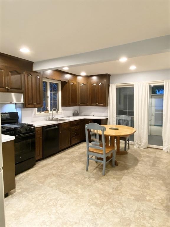 54 Hilltop St, Quincy, MA 02169 - kitchen with black appliances, a sink, under cabinet range hood, dark brown cabinetry, and light countertops