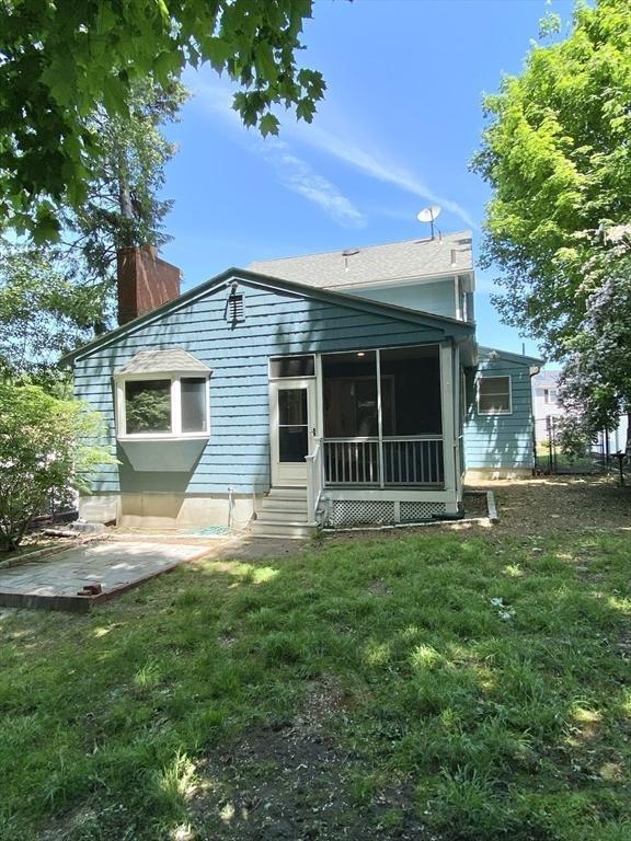 54 Hilltop St, Quincy, MA 02169 - back of house featuring a chimney, a sunroom, and a yard