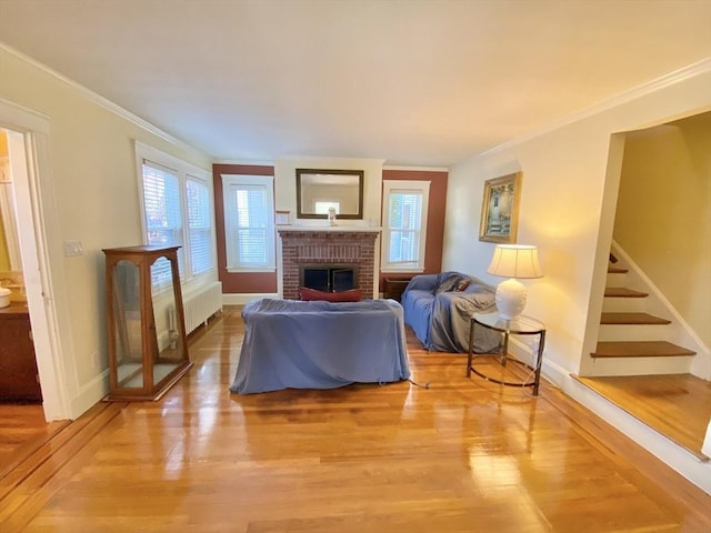 54 Hilltop St, Quincy, MA 02169 - living room with radiator heating unit, light wood finished floors, a fireplace, crown molding, and baseboards