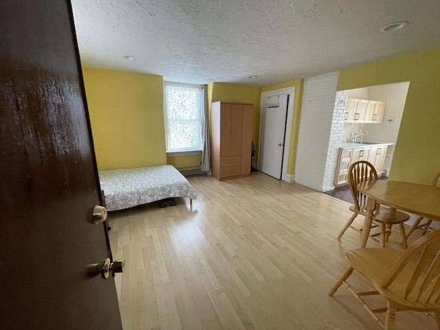 74 Newhall Unit 9, Lynn, MA 01902 - bedroom with light wood-type flooring, a textured ceiling, a sink, and baseboards